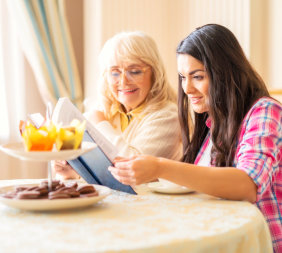 young woman and senior woman reading a book