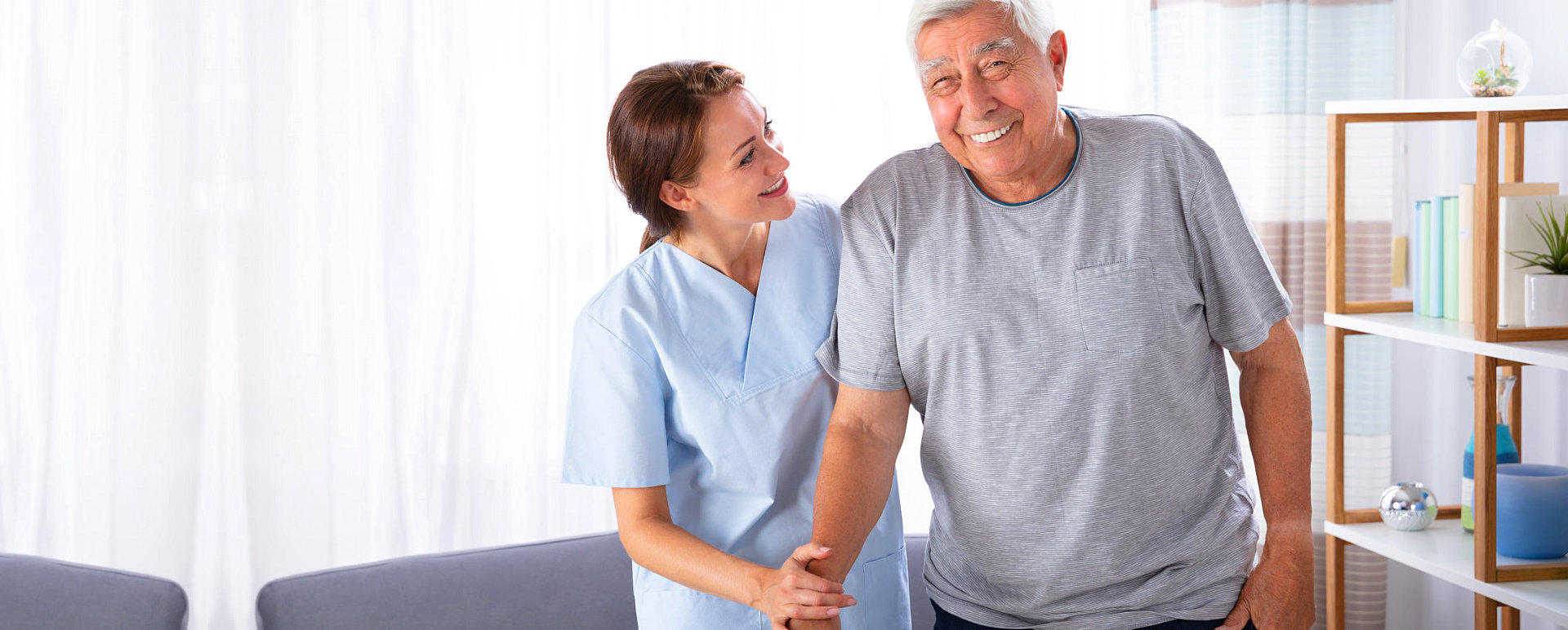 happ senior man assisted by his caregiver