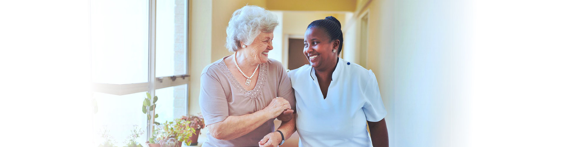 caregiver and senior woman walking together